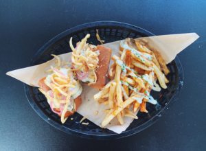 A beer-braised bratwurst topped with caraway sauerkraut, pickled red onion, beer cheese, and fried onions is one of 33 options on the new Beer Garden menu debuted Monday by Chef Terrell Wilson. / PHOTO BY EMILY GOWDEY-BACKUS