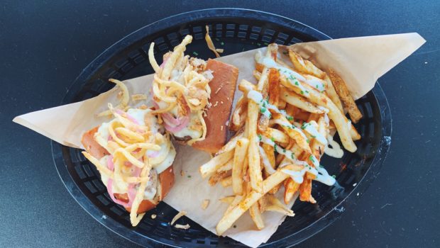 A beer-braised bratwurst topped with caraway sauerkraut, pickled red onion, beer cheese, and fried onions is one of 33 options on the new Beer Garden menu debuted Monday by Chef Terrell Wilson. / PHOTO BY EMILY GOWDEY-BACKUS